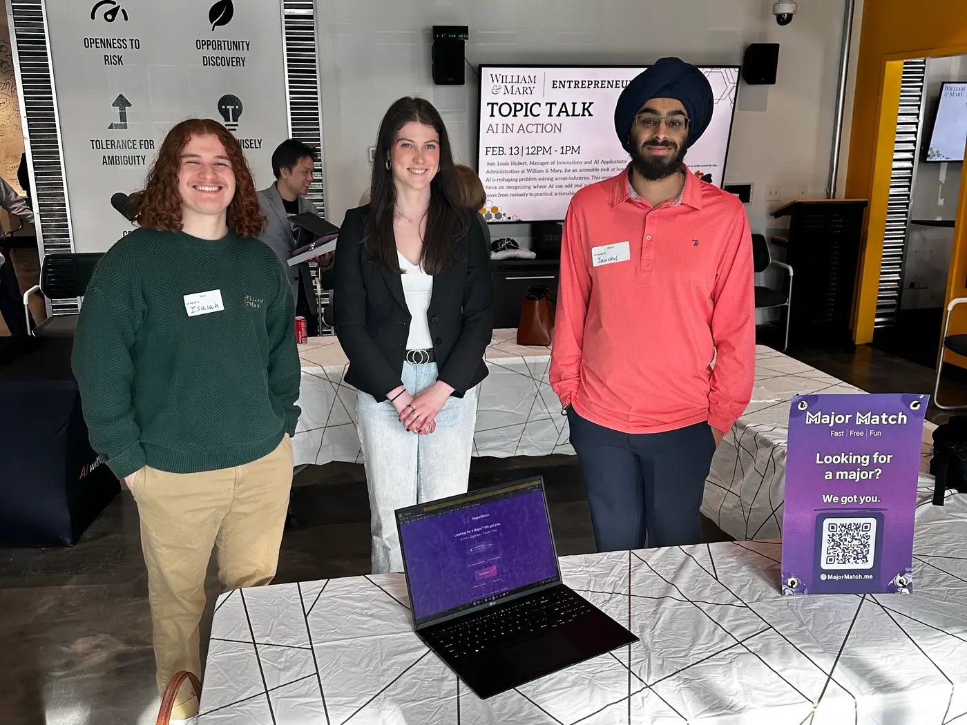 From left, Isaiah Nuñez, Allie Butler, and Jawand Singh behind a MajorMatch demo table with a laptop and a Looking for a major? sign, at a William & Mary Topic Talk titled AI in Action