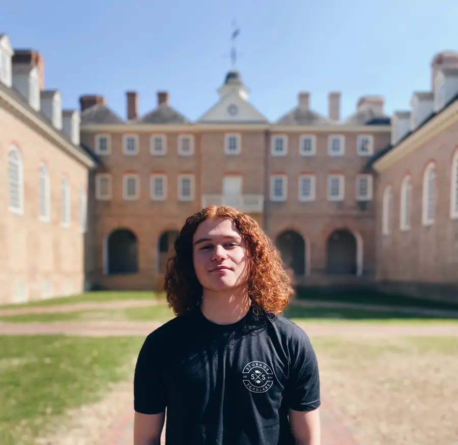 Isaiah in a Storage Scholars T-shirt in front of the Wren Building at William & Mary